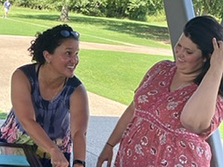 Two female residents talking at graduation celebration outdoors