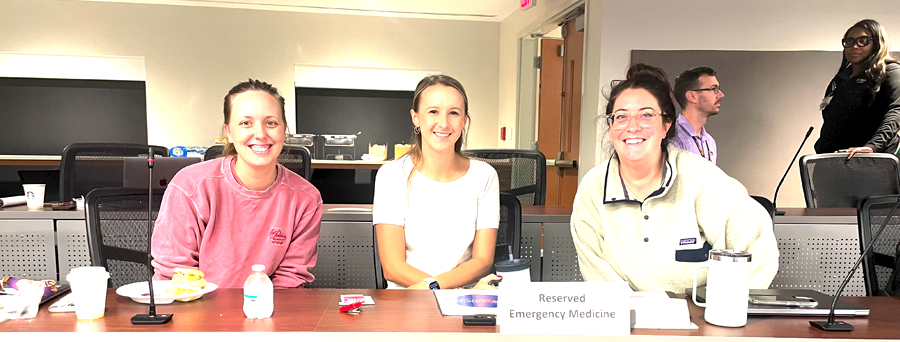 Three female residents sitting at a conference table