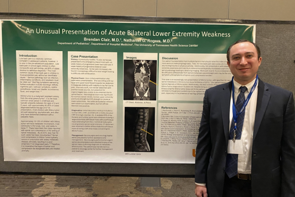 Resident standing before a poster presentation