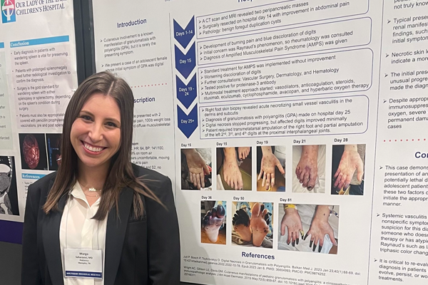 Resident standing before a poster presentation