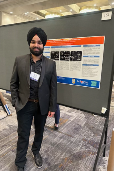 Resident standing before a poster presentation