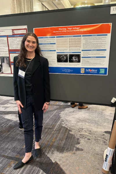Resident standing before a poster presentation
