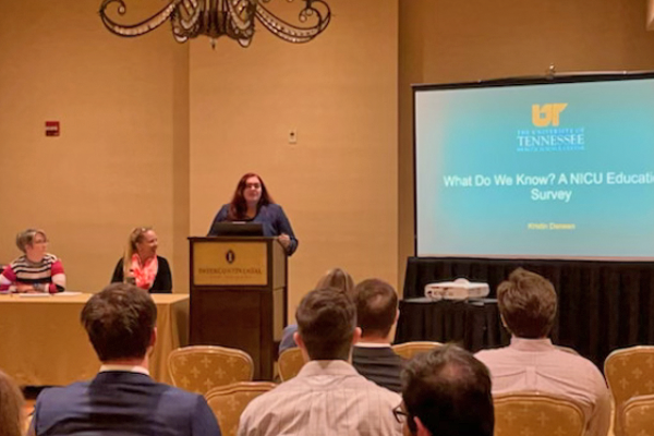 Presenter at a podium before a conference crowd