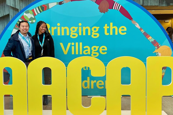Fellows in front of an AACAP sign