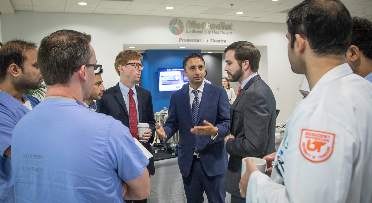 Dr. Kadaria speaking with doctors in the hallway of the conference