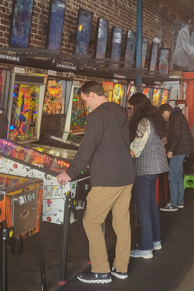 Residents playing pinball machines indoors