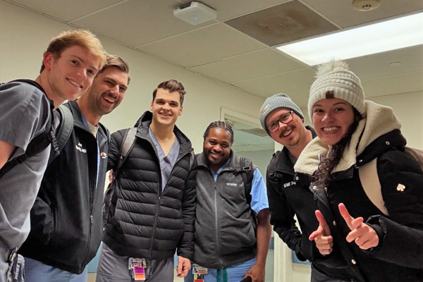 Residents wearing winter attire in a hospital hallway